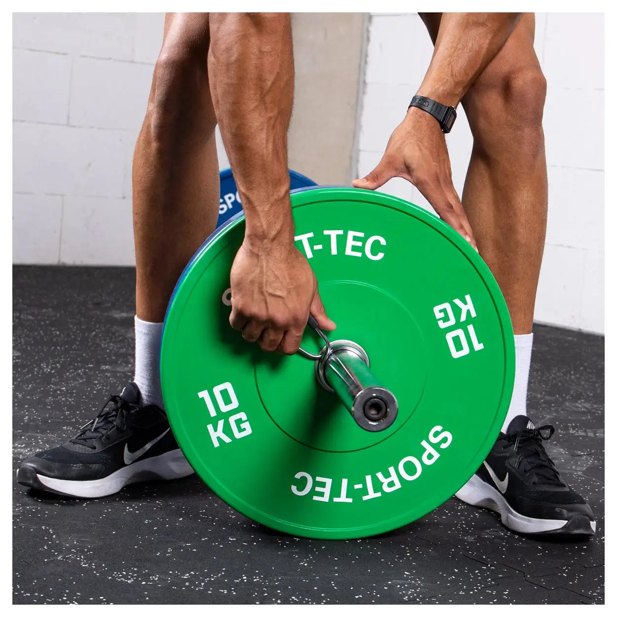 Mann steckt Federverschluss Sport-Tec auf Langhantel mit 10 kg Scheibe