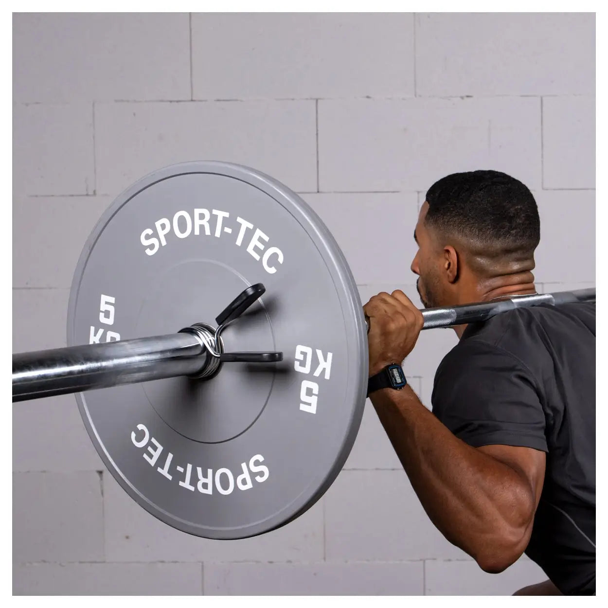 Mann nutzt Federverschluss auf Langhantel mit 5kg Hantelscheibe für Kniebeugen