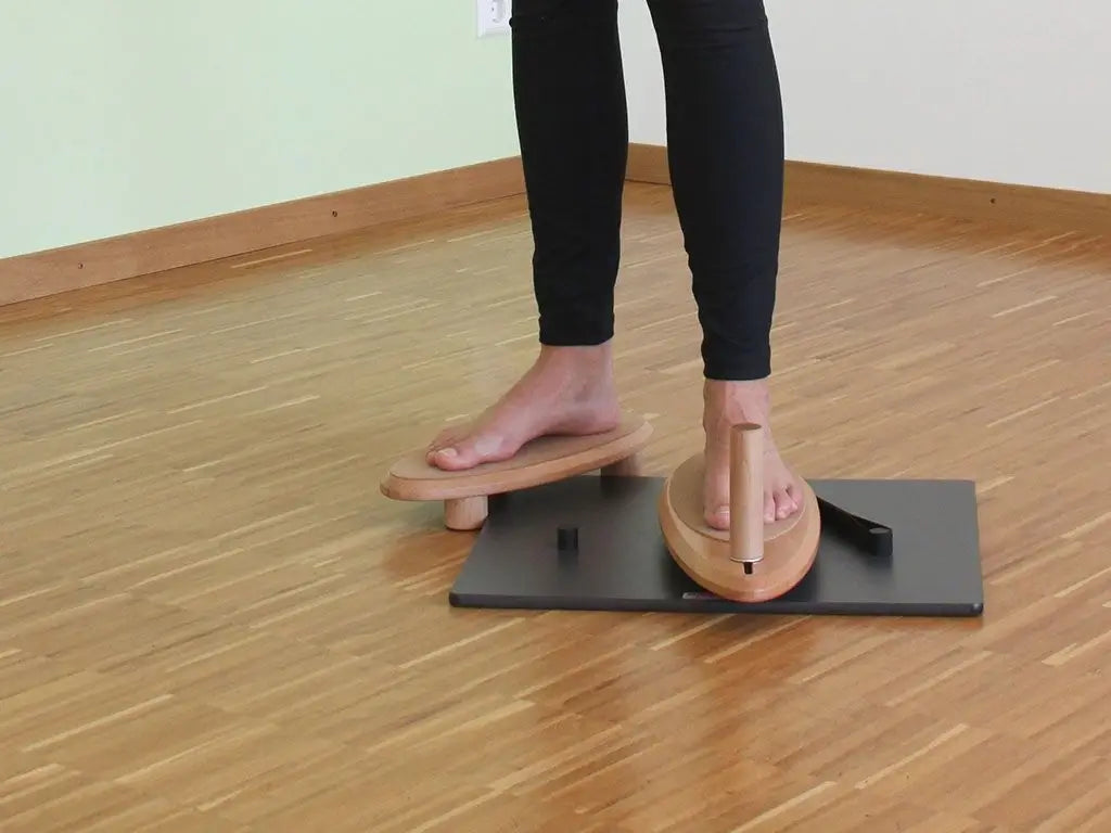 Person steht und trainiert Füße mit dem Pedalo PhysioFlip auf dem Boden