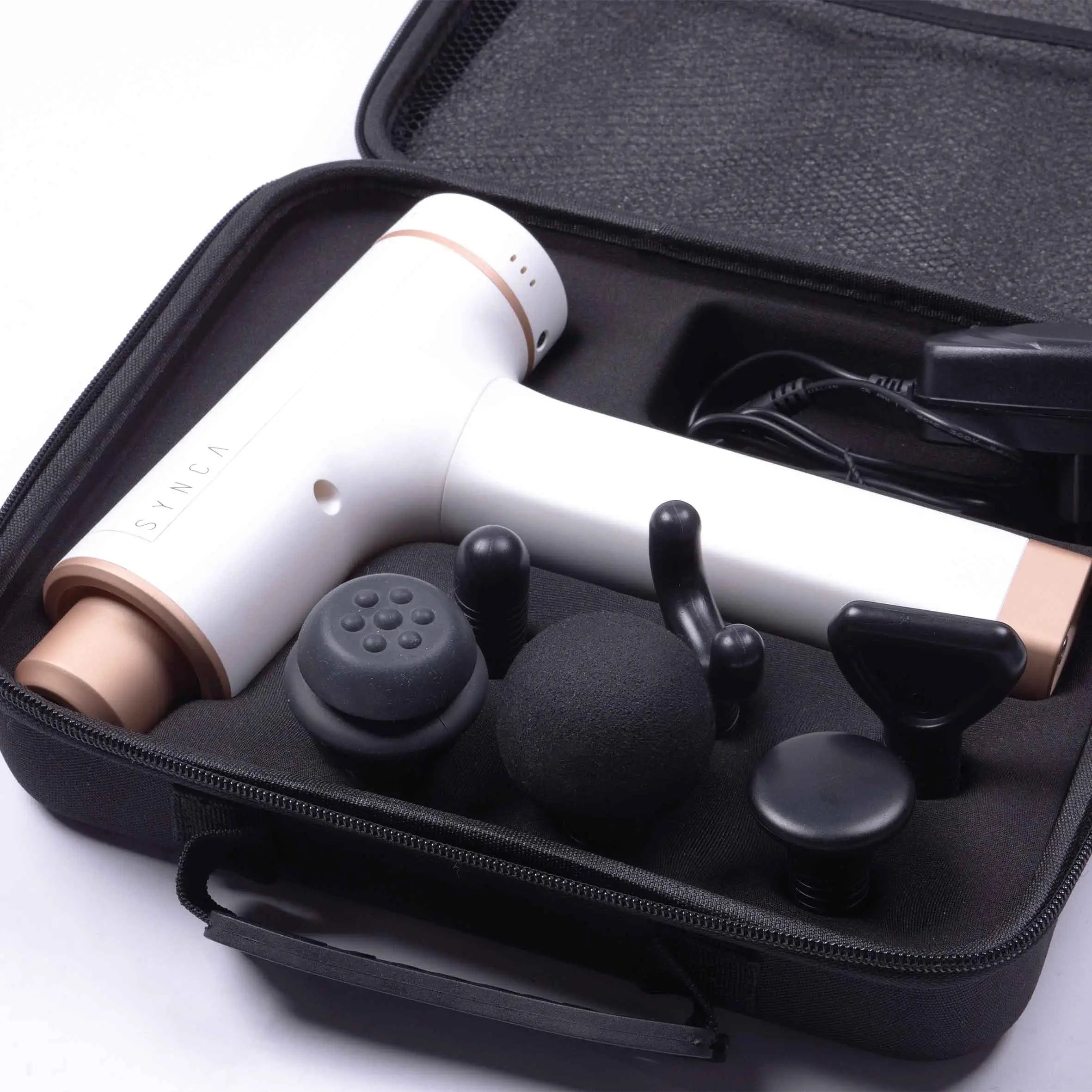 Faszien-Massagepistole Synca Kitta mit Zubehör in geöffnetem Tragekoffer