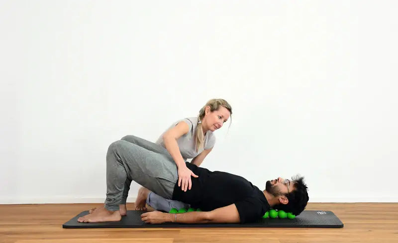 Therapeutin behandelt Rücken eines Patienten mit Spinefitter SISSEL