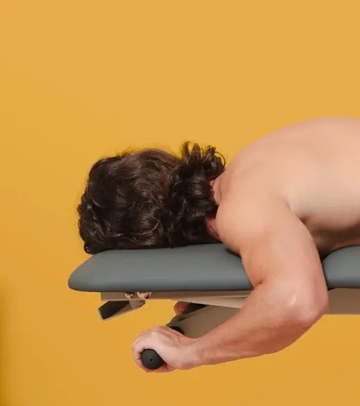 Patient liegt auf Kopfteil der Naggura Swop 2 Pro und verwendet die Handlenker als Griff