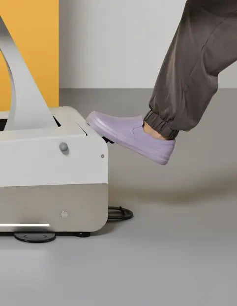 Therapeut betätigt unsichtbares Radsystem über Steuerung mit Fuß am Kopfteil der Therapiebank Naggura Swop 2 Pro