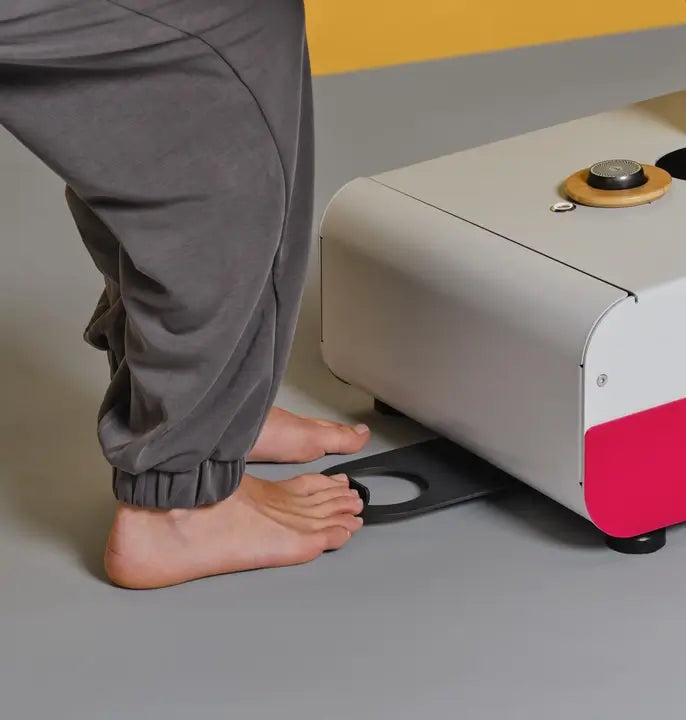 Therapeut betätigt Höhenverstellung über Space-Ball-Rundumschaltung am Kopfende der Naggura Swop 2 Pro mit Fuß