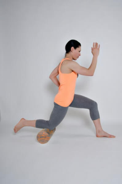 Frau rollt Knie auf Faszienrolle Matrix aus