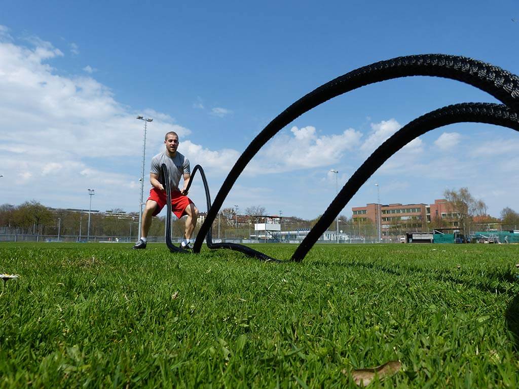 Mann trainiert mit Battle Rope Blackthorn 35mm auf Wiese