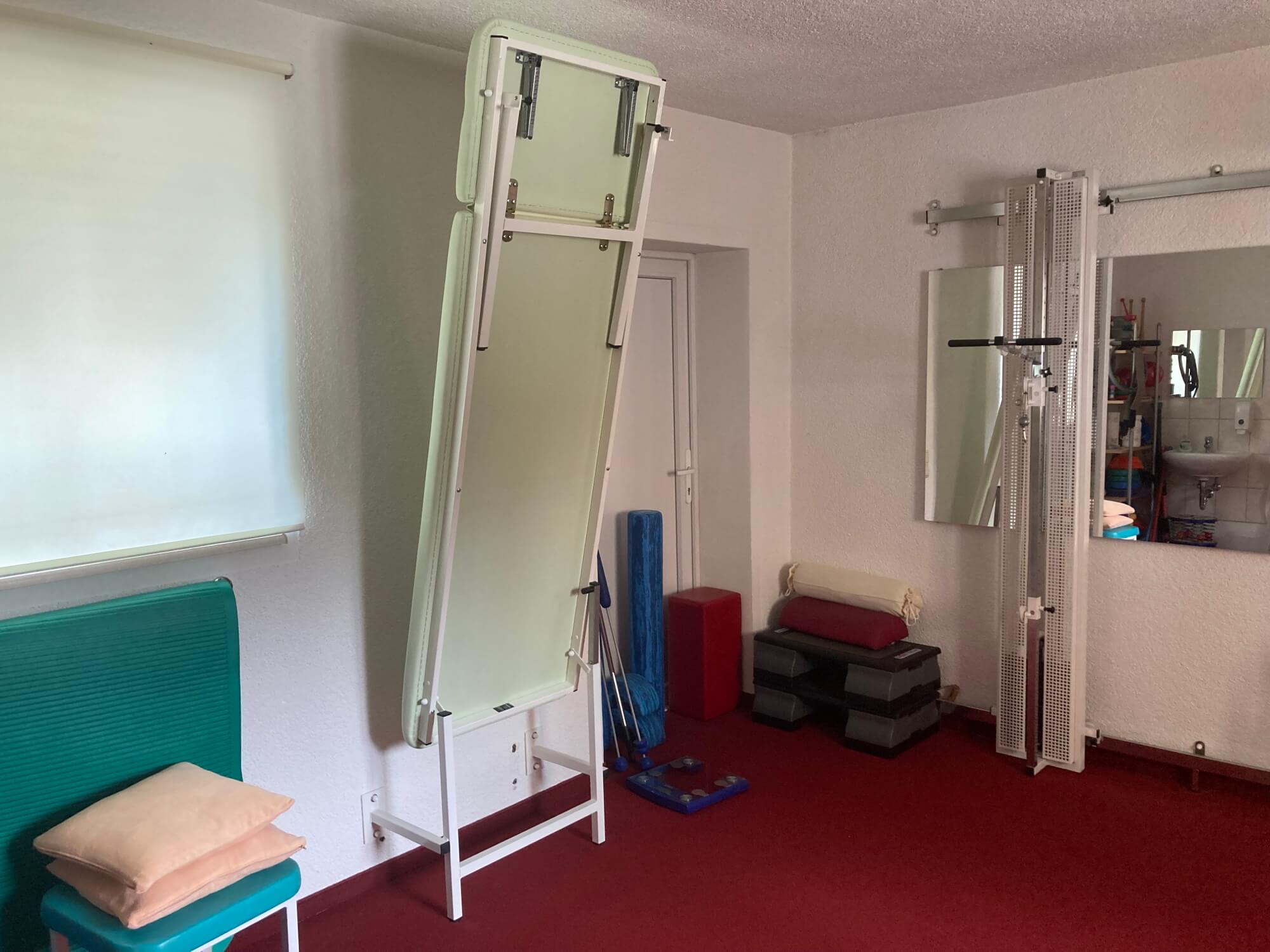 Gebrauchte Wandklappliege Vario mit Kopfteil im hochgeklappten Zustand in Praxis