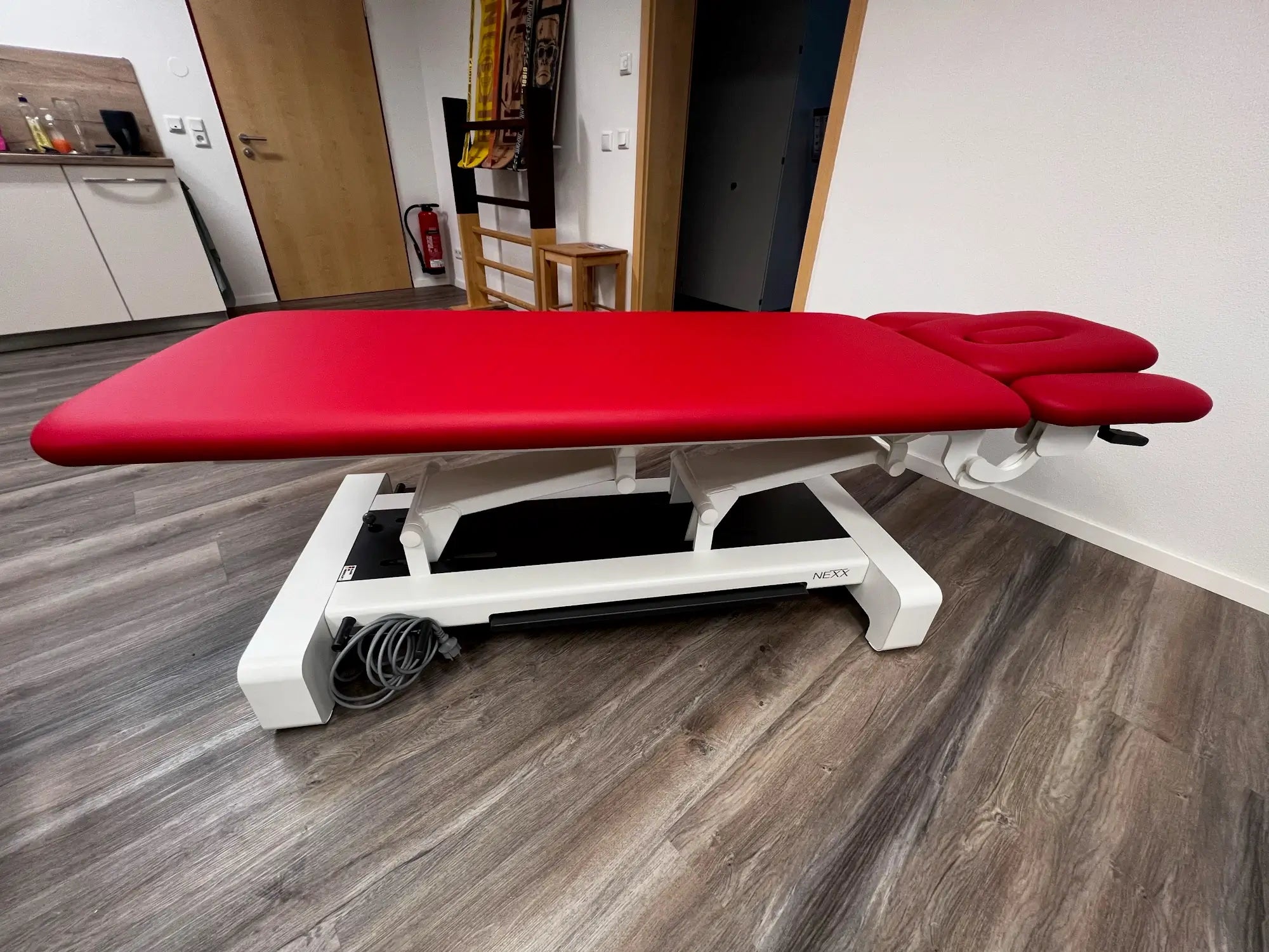 Seitenansicht der gebrauchten Therapieliege NEXX 2 in Rot