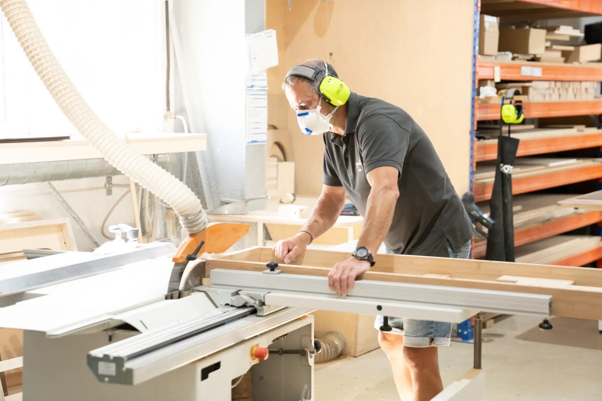 Mitarbeiter sägt Holz für Therapieliege mit Kreissäge
