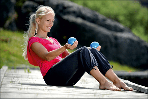 Frau trainiert mit zwei Pilates-Bällen SISSEL® Toning