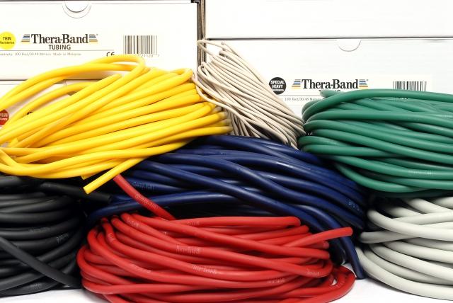 7 Therabänder Tubing Länge 7,5 m in verschiedenen Farben vor Verpackungen