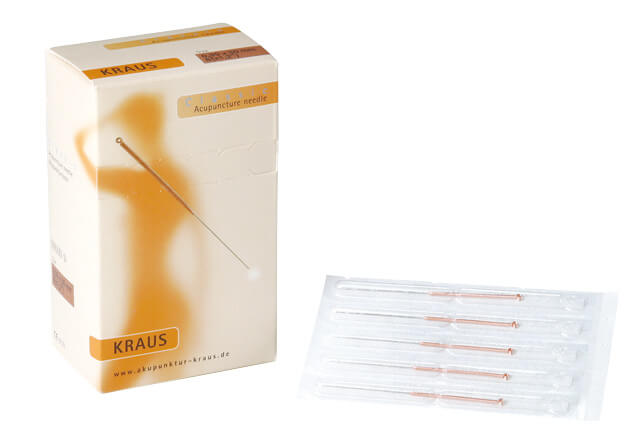 Vier Akupunkturnadeln Classic in gemeinsamer Verpackung neben Pappkarton
